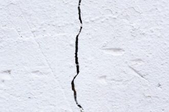 Fissures sur un mur de maison nécessitant une évaluation des risques